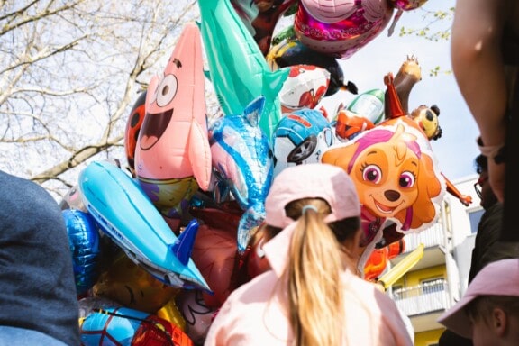 Familienfest mit bunten Ballons und fröhlichen Kindern.